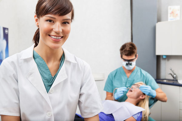 Assistant with dentistry work in the background